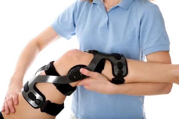 Hands adjusting a knee brace